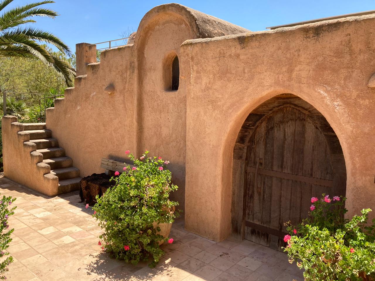 Arched timber entry and textured plaster walls at the Goussous residence
